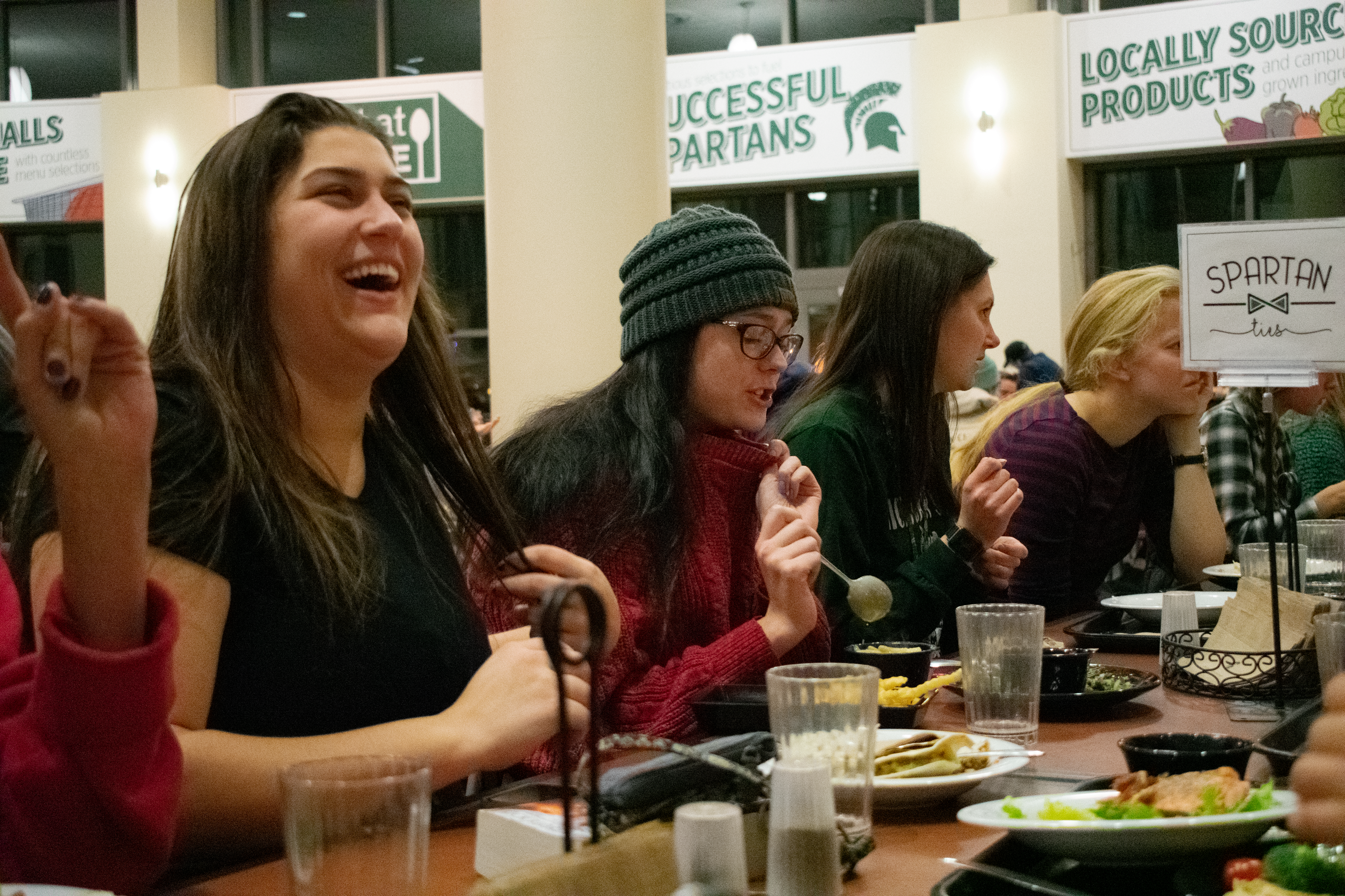 woman laughing during conversation at Spartan Ties dinner